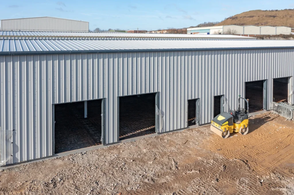 Warehouse units under construction with a site roller